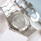 Engraved case back on a stainless steel wristwatch with a sunburst medallion.