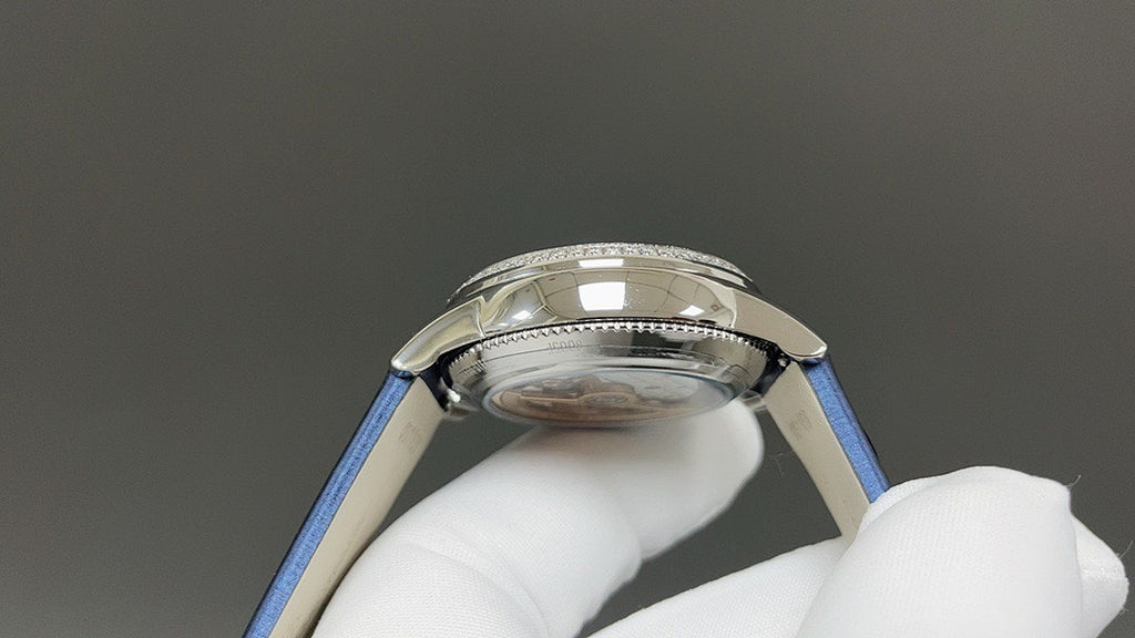 Luxury wristwatch side view with polished silver case and blue leather strap