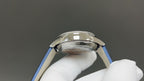 Luxury wristwatch side view with polished silver case and blue leather strap