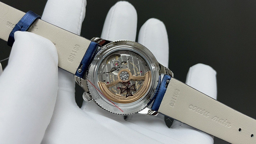 Luxury wristwatch with blue leather strap, open caseback showing mechanical movement