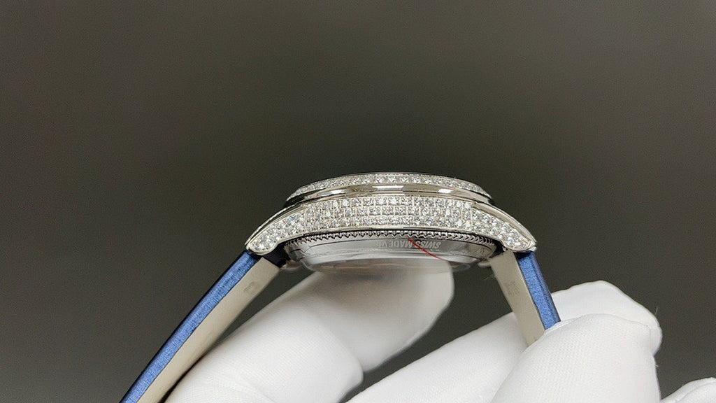 Silver watch case top with blue strap, studded bezel and side crown detail