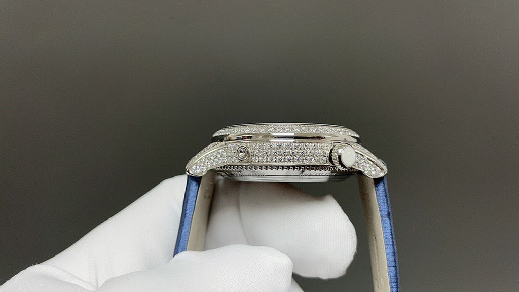 Silver watch case side with blue strap, textured bezel and crown detail