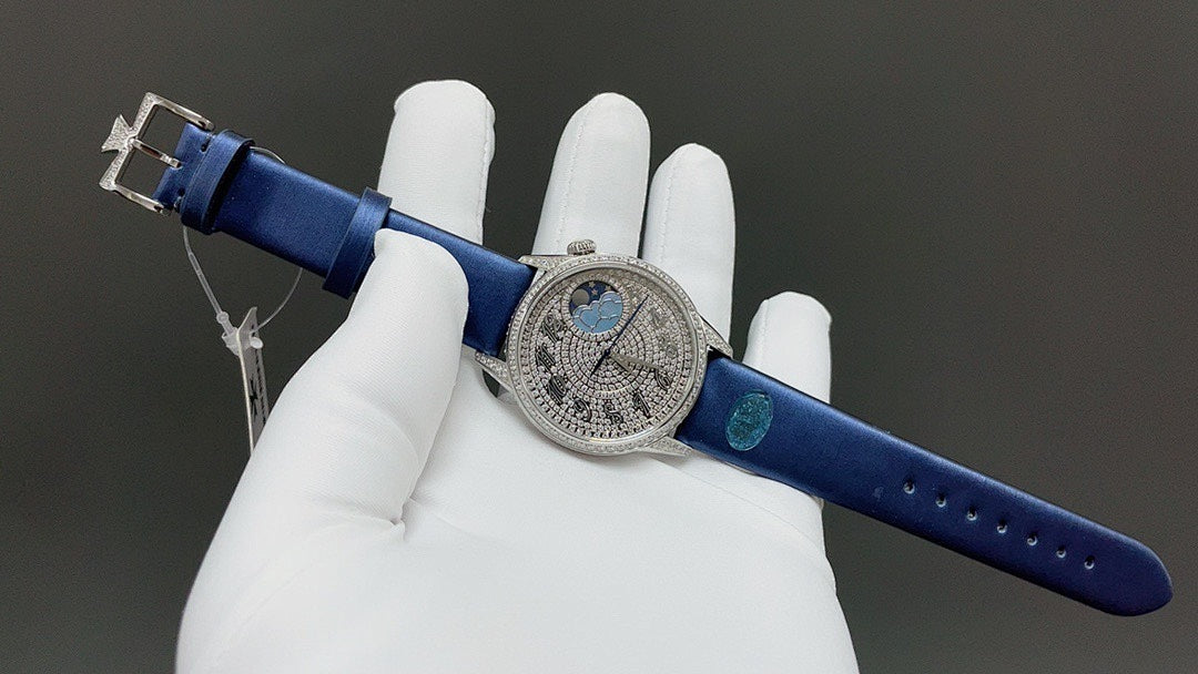 Round watch with blue leather strap, silver case and blue dial, shown on gloved hand