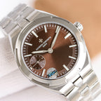 Stainless steel wristwatch close-up with brown dial and crown at right