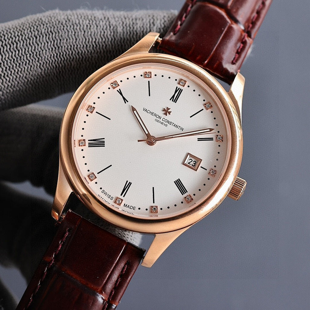 Gold wristwatch with white dial, dark brown leather strap, and date window showing 28