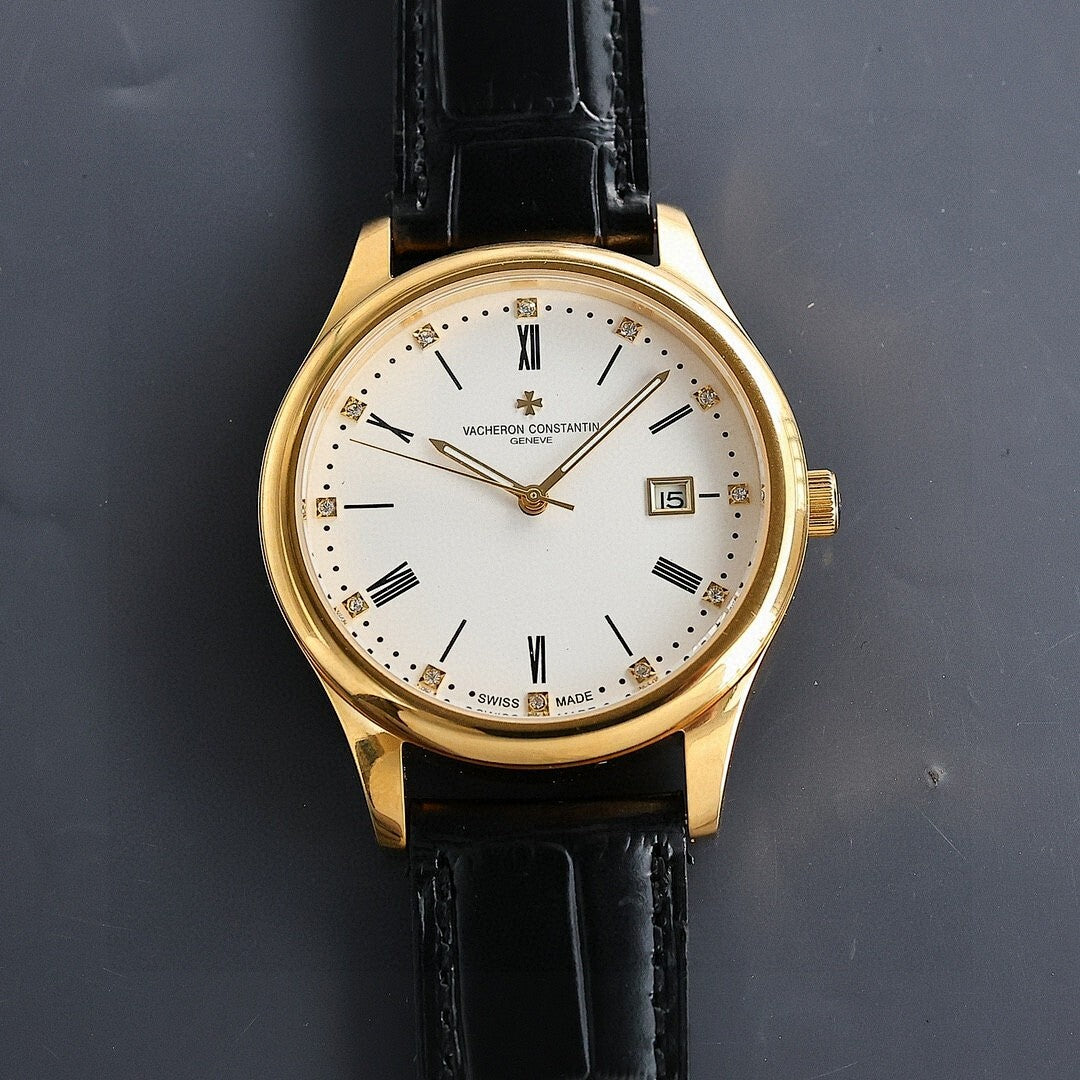 Gold wristwatch with white dial and black leather strap, date window showing 15