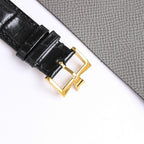 Black leather watch strap with gold-tone buckle and clasp hardware