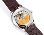 Vacheron Constantin wristwatch open to reveal movement with gold-toned gear, brown leather strap