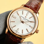 Gold wristwatch with white dial and brown leather strap, date 24