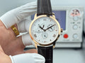 Gold-tone Vacheron Constantin watch with white dial, Roman numerals, black leather strap