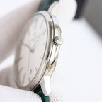 Silver-tone wristwatch with green leather strap and crown, angled side view