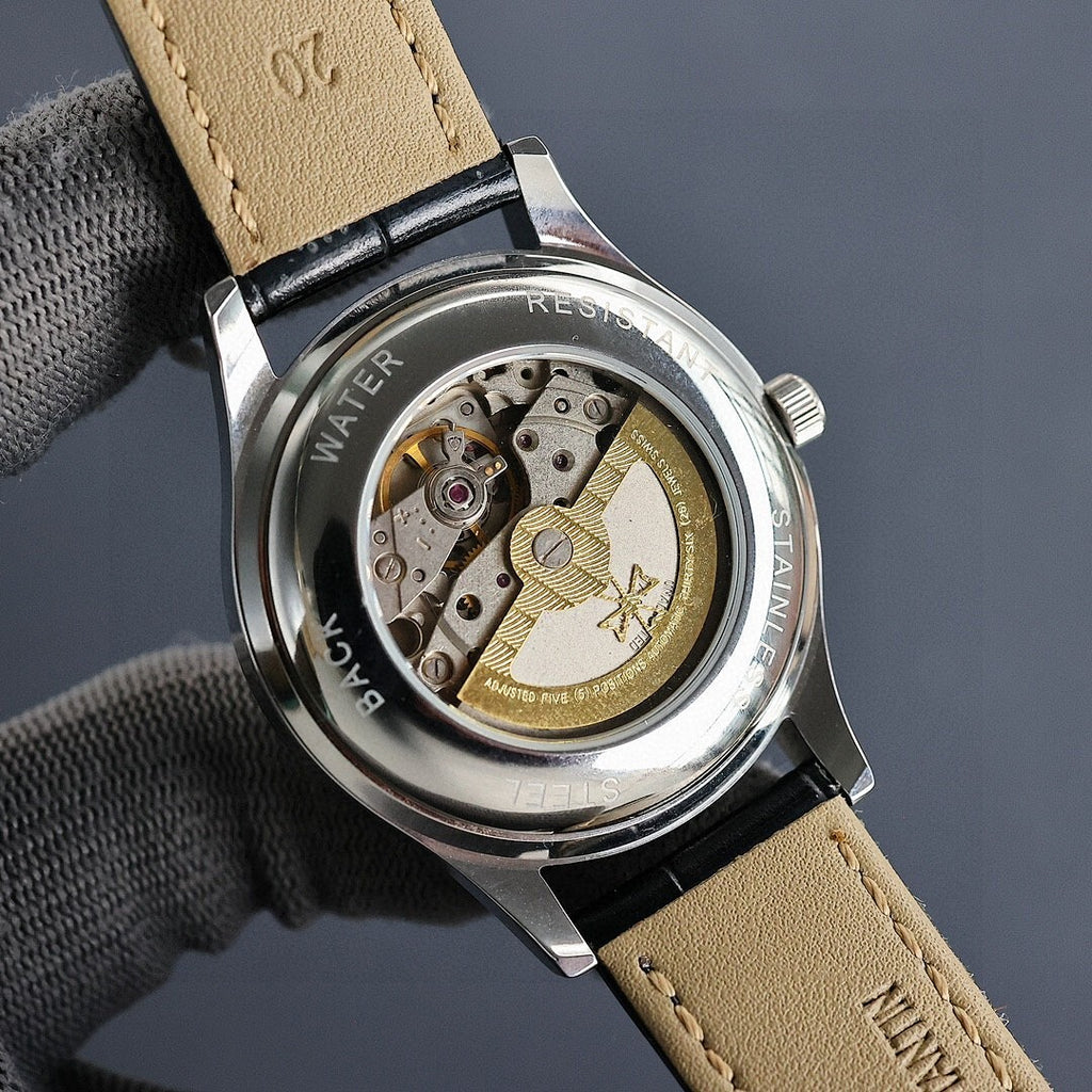 Vacheron Constantin watch caseback with exposed movement, tan leather strap, metal bezel