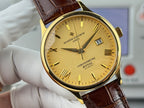 Gold wristwatch with yellow dial and brown leather strap, close-up front view