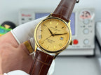 Gold wristwatch with yellow dial and brown leather strap, held with dial facing camera