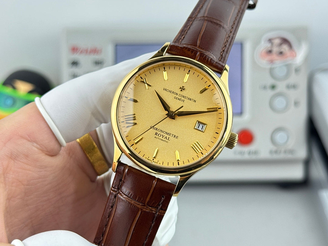 Gold wristwatch with yellow dial and brown leather strap, held with dial facing camera