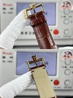 Brown leather strap wristwatch with gold buckle clasp, shown from side