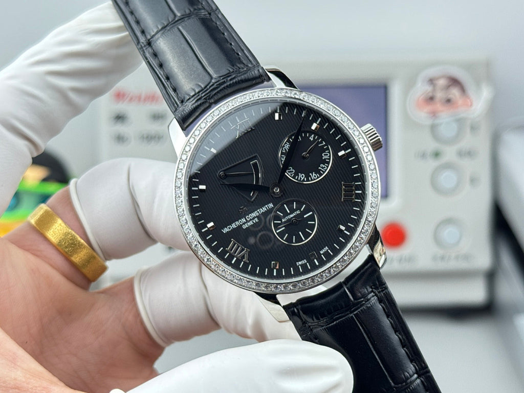 Vacheron Constantin watch with black dial, silver bezel, and black leather strap in hand