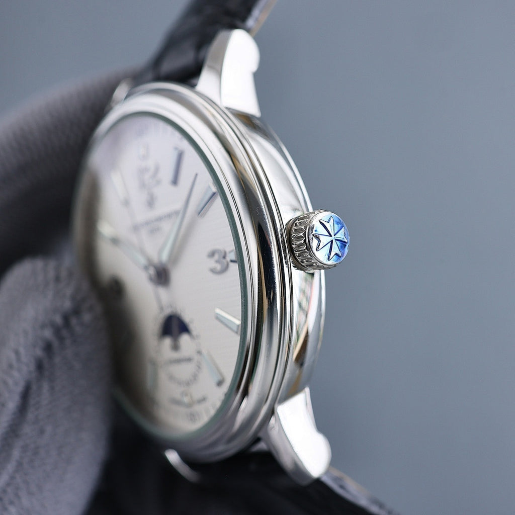 Automatic wristwatch crown with blue emblem, silver case, cream dial, black strap