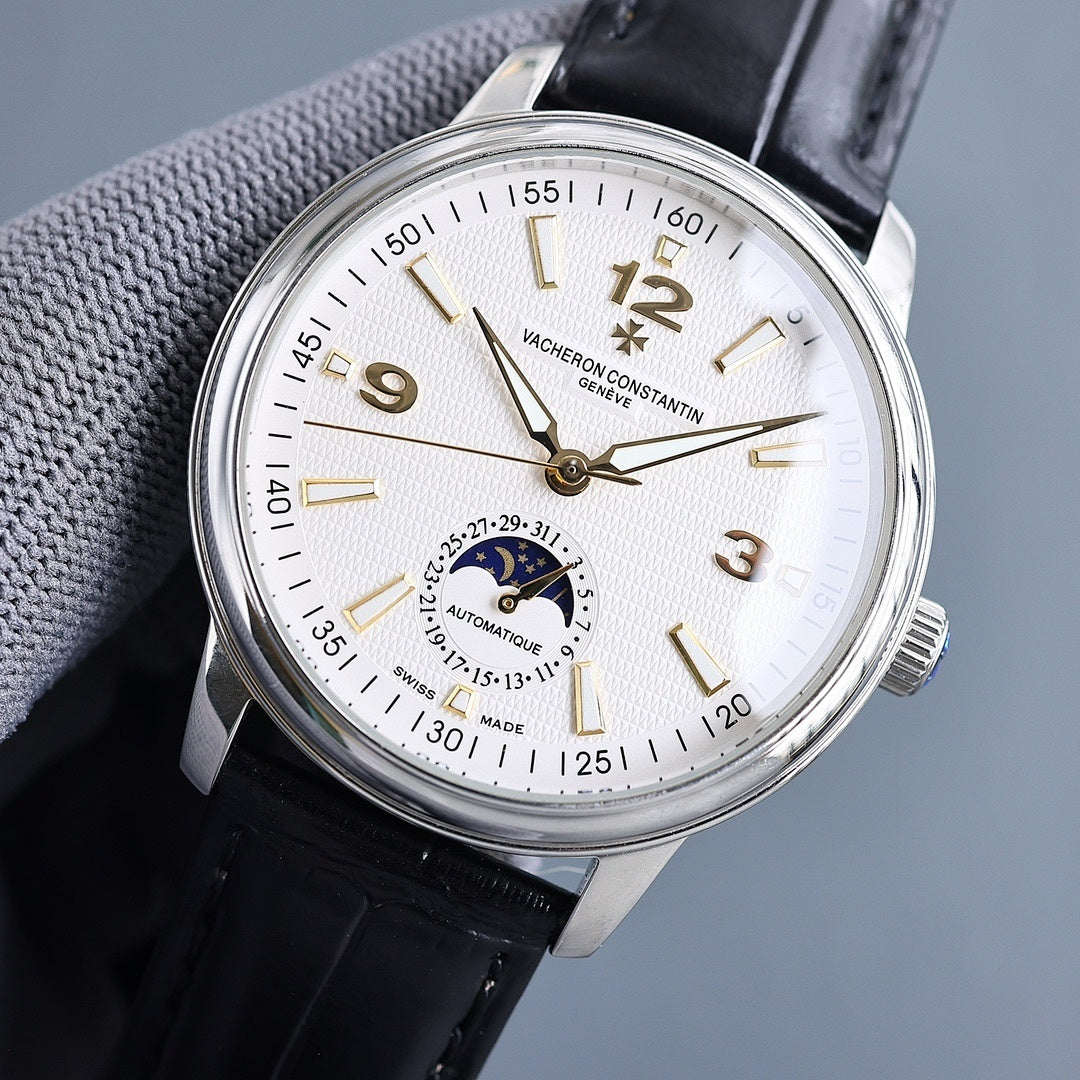 Automatic wristwatch dial close-up, cream face, gold hands and markers, black strap
