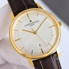 Gold dress watch with white textured dial, brown leather strap, gold hands, and date window at 9