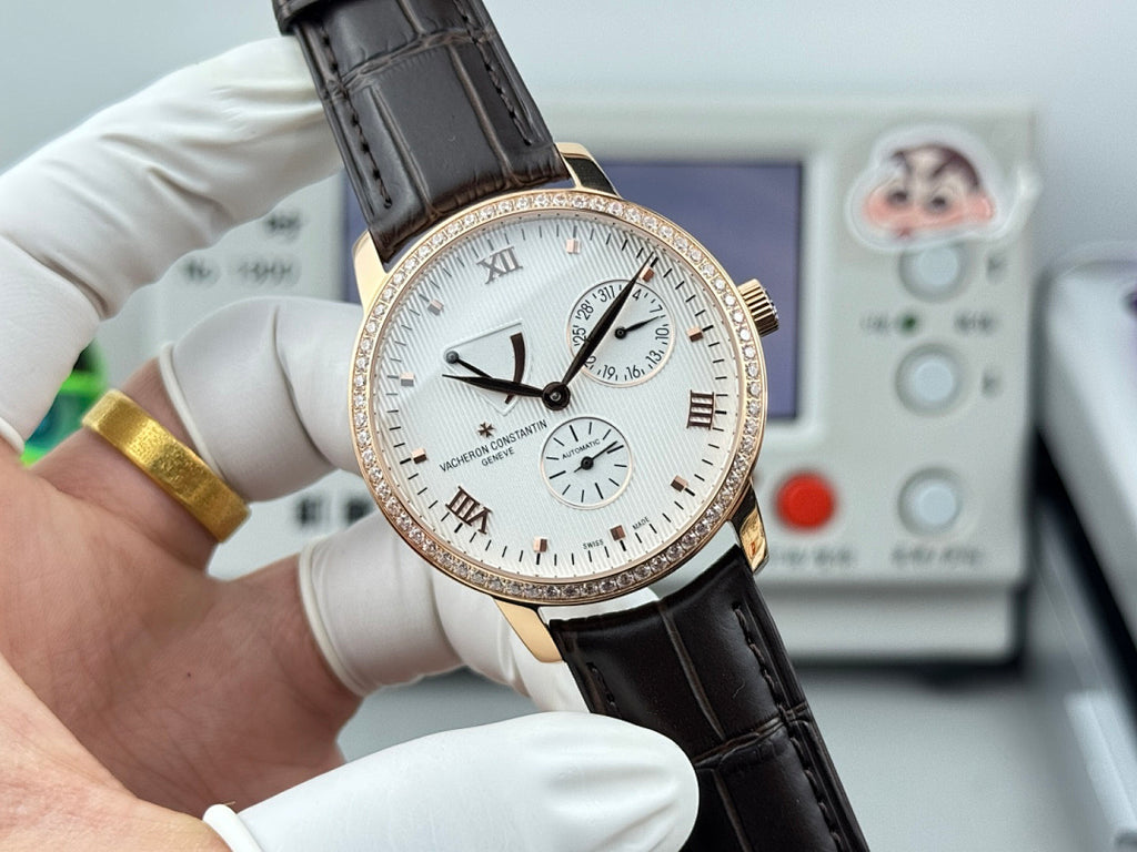 Luxury wristwatch front close-up with white dial, rose-gold bezel, black leather strap, subdials.
