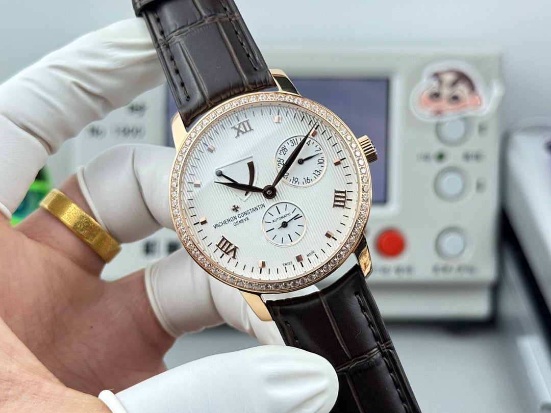 Luxury wristwatch front close-up with white dial, rose-gold bezel, black leather strap, subdials.
