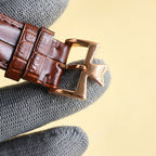 Brown leather watch strap with gold clasp buckle and star-shaped keeper