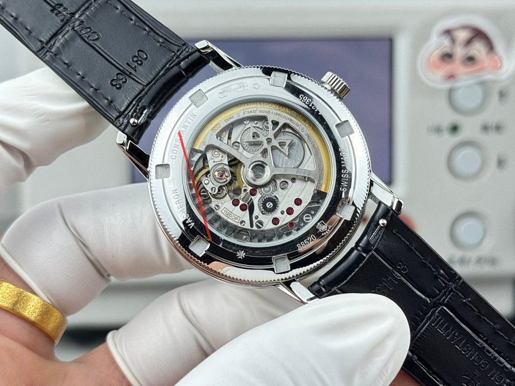 Vacheron Constantin watch caseback with exposed movement, silver case, black leather strap.