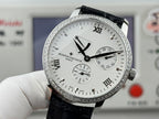 Vacheron Constantin wristwatch with textured white dial, black leather strap, silver bezel.