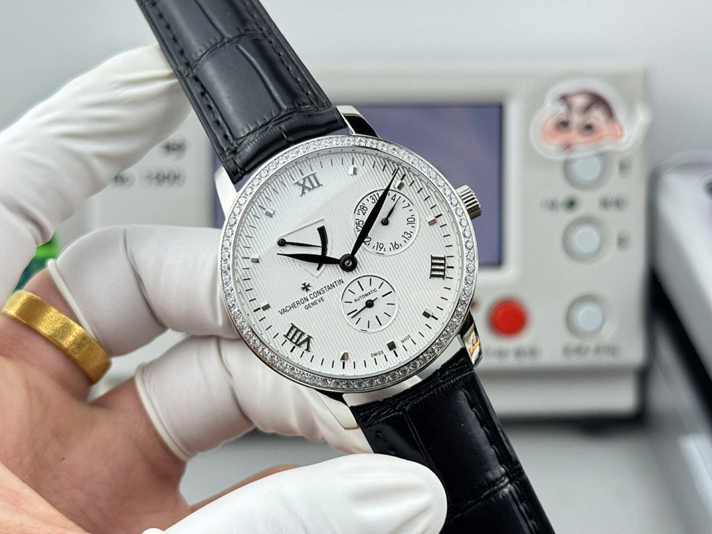 Vacheron Constantin wristwatch with white dial, black leather strap, silver case and bezel.