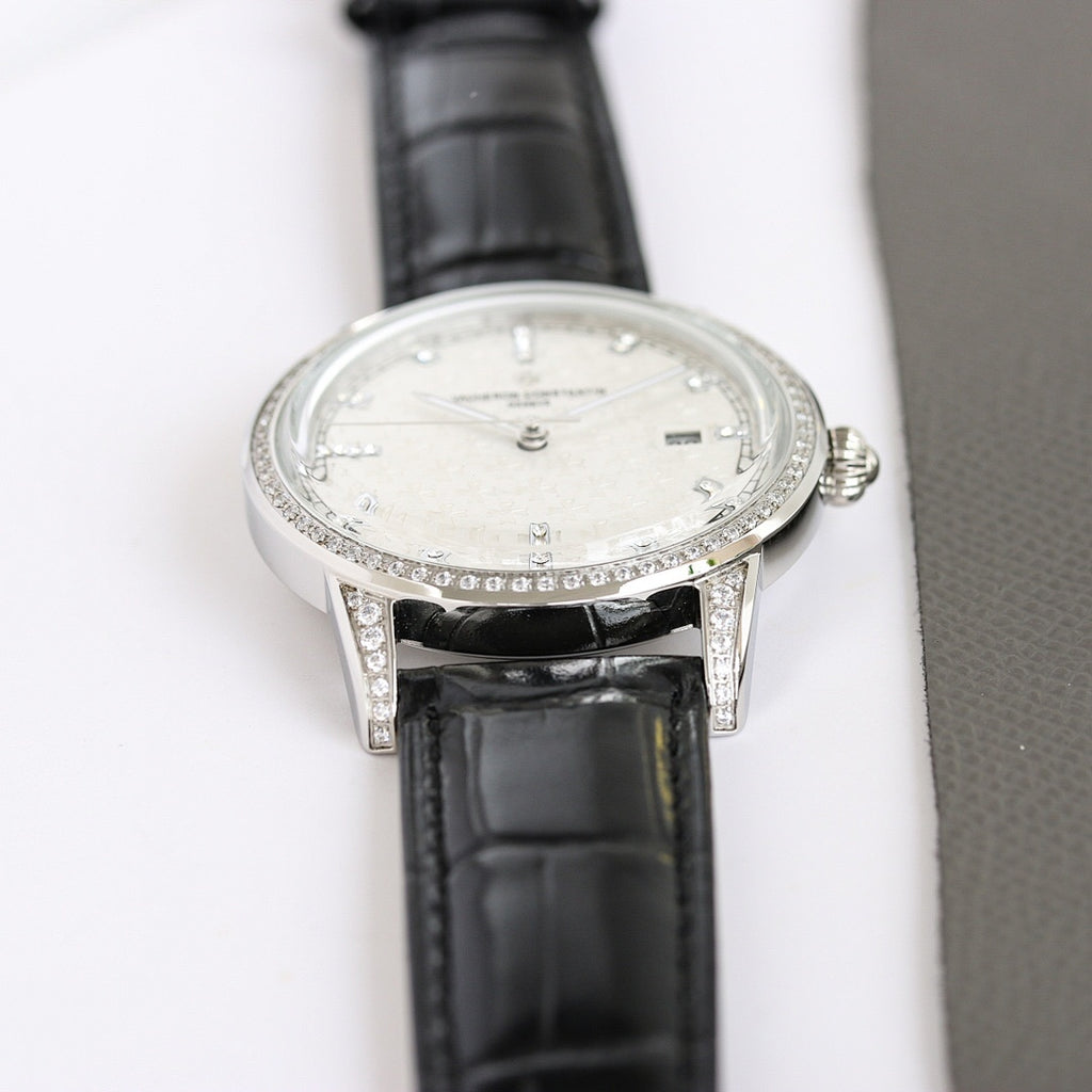 Silver luxury wristwatch with white dial, diamond bezel, black leather strap