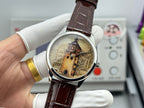 Watch with brown leather strap and silver case, gold-tone city dial held in hand.