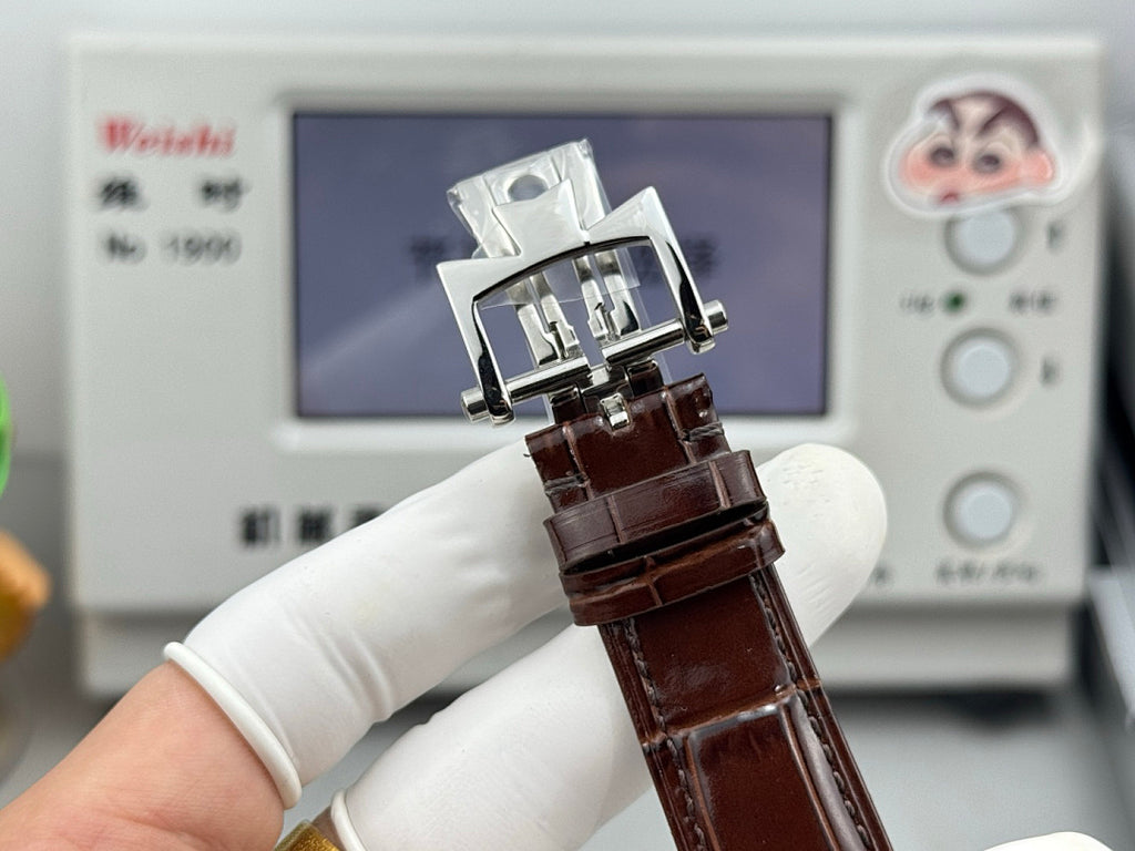 Brown leather strapped watch with silver clasp and rectangular case detail.