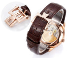 Rose-gold wristwatch detail with brown leather strap and clasp hardware