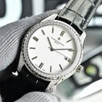 Vacheron Constantin watch with diamond bezel, white dial, and black leather strap.