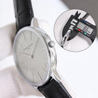 Wristwatch with white dial and black leather strap, side profile with crown visible.