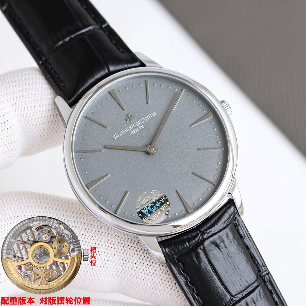 Wristwatch with gray dial and black leather strap, silver case angled on cushion.