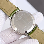 Vacheron Constantin watch caseback, brushed metal with text, green leather strap