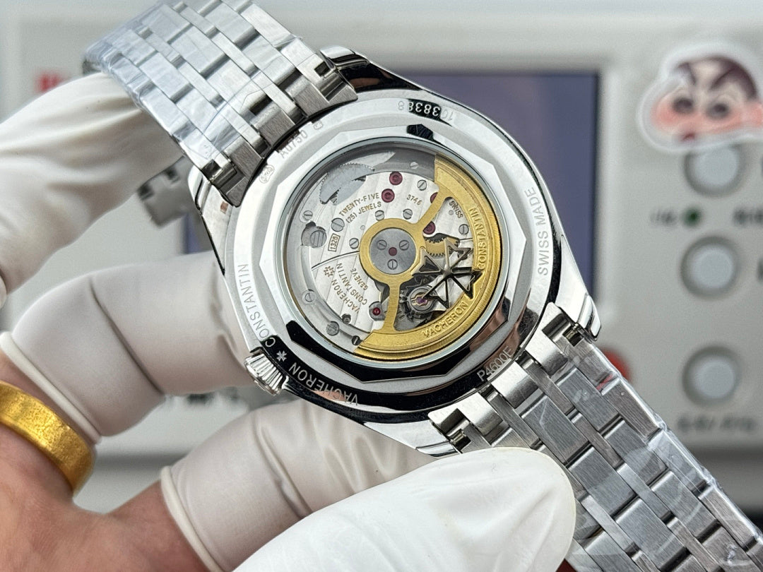 Vacheron Constantin watch close-up with open case showing gold-toned movement and steel strap