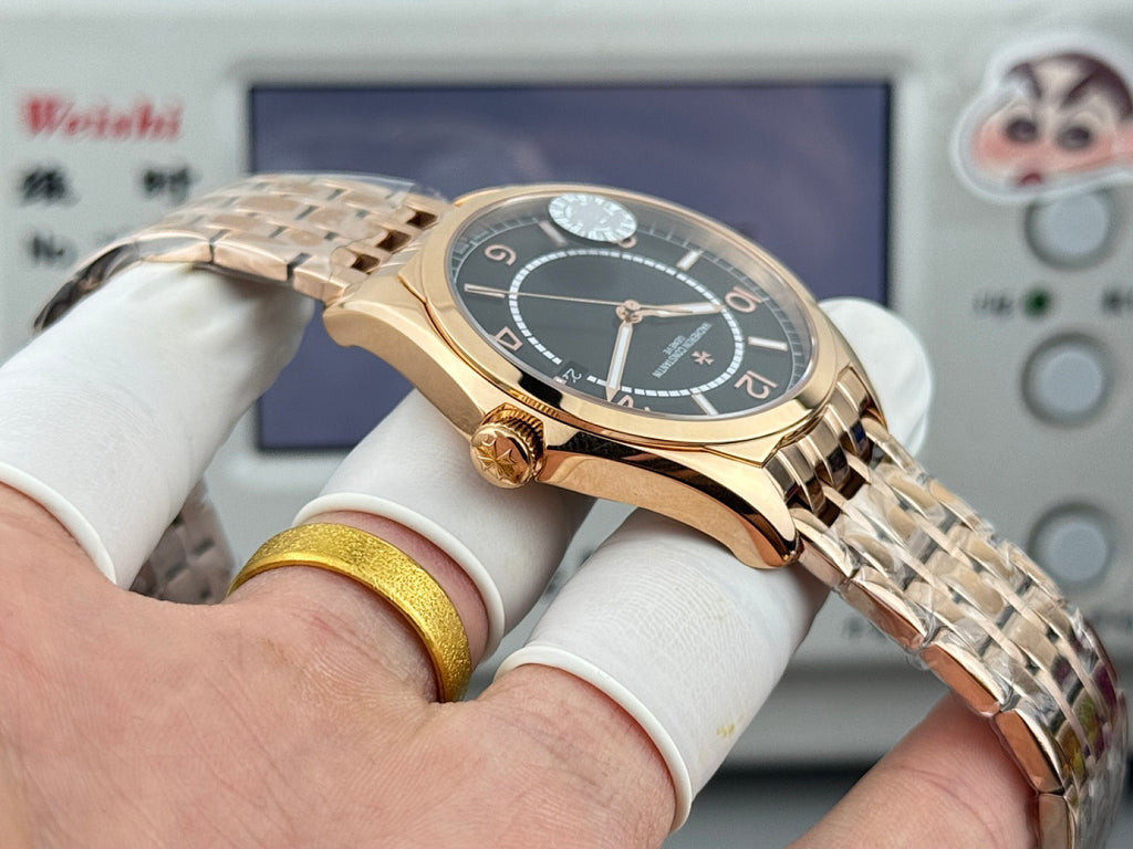 Gold-tone wristwatch with black dial, roman numerals, and metal bracelet