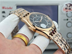 Gold-tone wristwatch with black dial, date window, and metal link bracelet