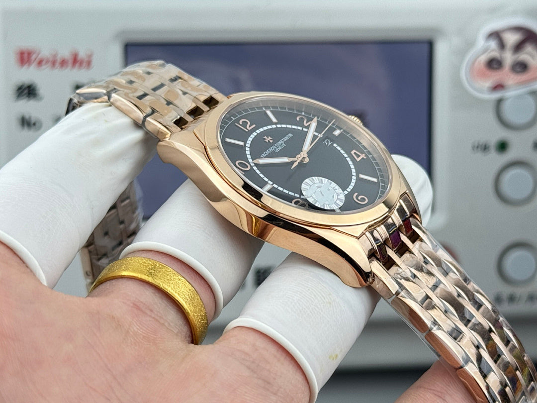 Gold-tone wristwatch with black dial, date window, and metal link bracelet