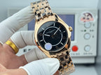 Gold-tone wristwatch with black dial, baton markers, and metal link bracelet