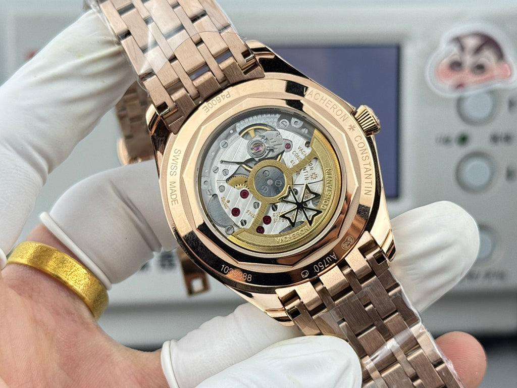 Gold-tone wristwatch showing see-through caseback with mechanical movement and metal bracelet