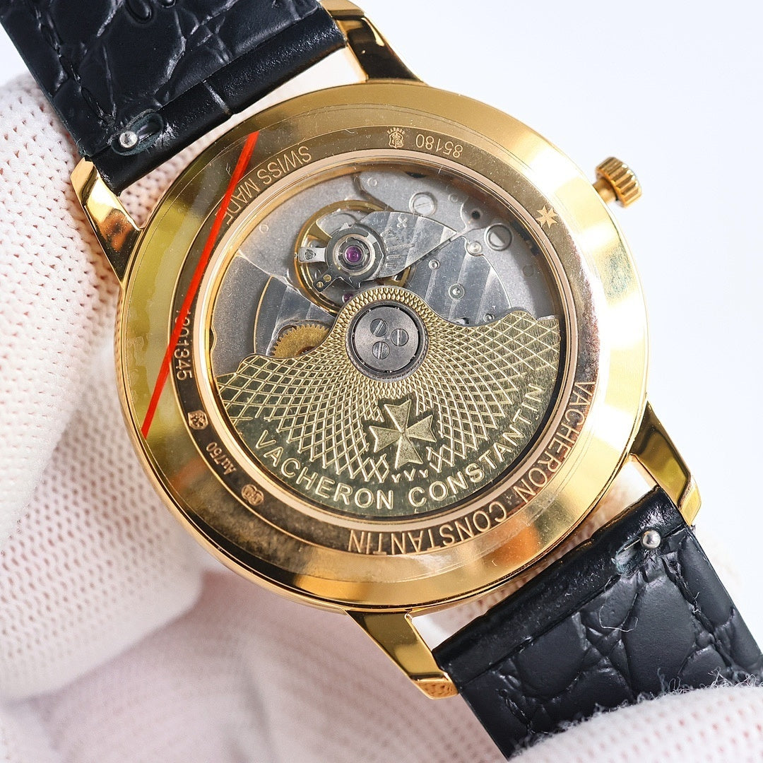 Automatic watch caseback in gold with engraved movement and serial markings, black strap