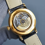 Vacheron Constantin watch caseback in gold with visible mechanical movement under glass.