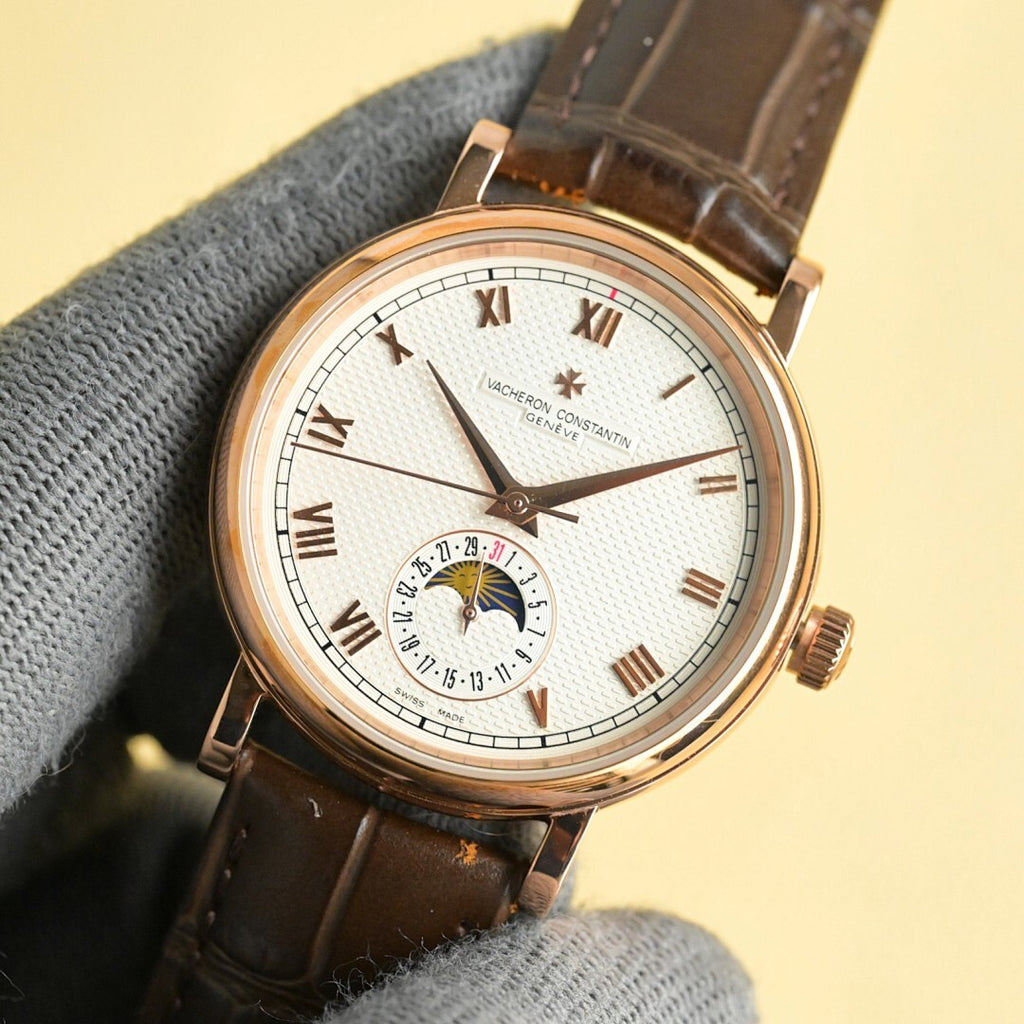 Vacheron Constantin watch dial close-up with gold hands, Roman markers, brown leather strap.