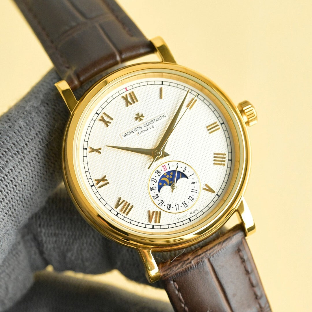 Vacheron Constantin watch with gold case, white dial featuring subdial, brown leather strap.