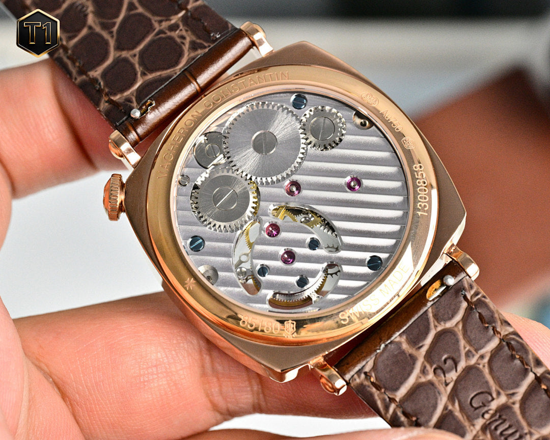 Vacheron Constantin watch with white dial, gold case, visible gears, brown leather strap
