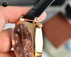 Mechanical wristwatch side view with rose-gold case and black leather strap